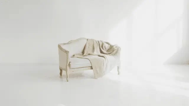 白い部屋に白いソファとひざ掛けの写真